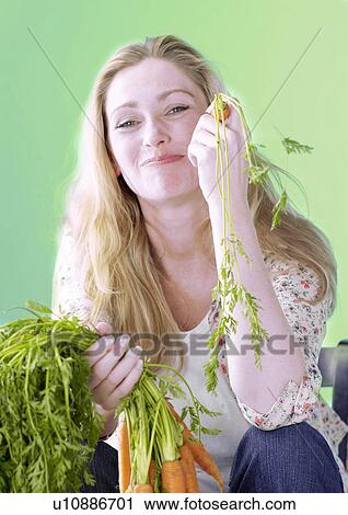Stock Image - Blonde woman with carrots. Fotosearch
