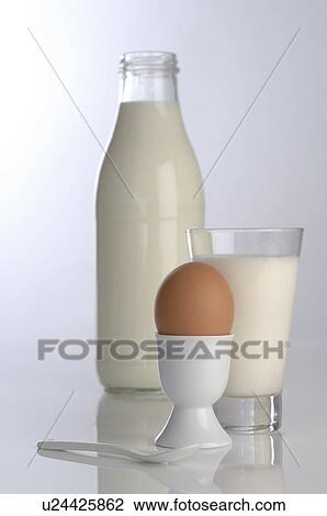 Stock Image - Organic milk in bottles and egg cup. Fotosearch