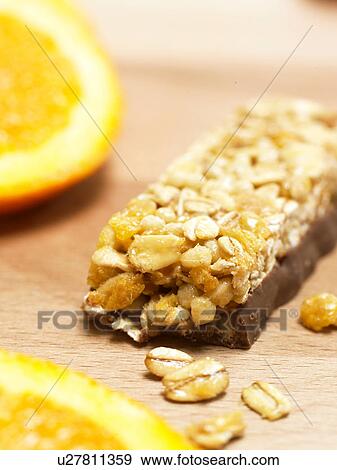 Stock Photo - Chocolate bar with cereals and orange. Fotosearch