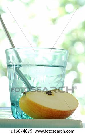 Stock Photo - Glass of water and a piece of apple. Fotosearch