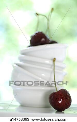 Stock Image - Stack of white bowls and cherries. Fotosearch
