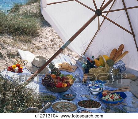 Picture - Picknick am Strand unter dem Sonnenschim. Fotosearch