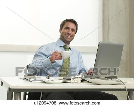 Business man is drinking coffee View Large Photo Image Stock Photo - Business man is drinking coffee. Fotosearch