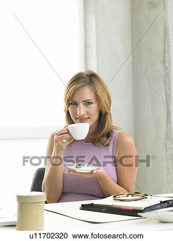 Stock Image - Business woman is drinking coffee. Fotosearch