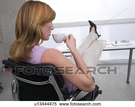 Woman is drinking coffee at his desk View Large Photo Image Stock Photography - Woman is drinking coffee at his desk. Fotosearch