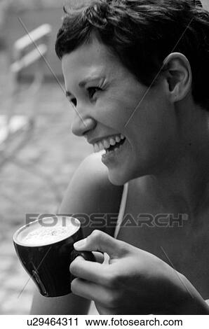 Stock Image - Laughing woman with cappuccino cup. Fotosearch