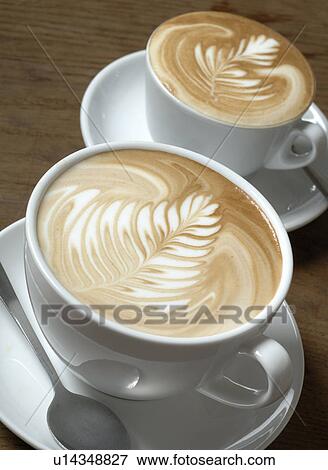 Two cappuccini with milk froth ornaments View Large Photo Image Stock Photo - Two cappuccini with milk froth ornaments. Fotosearch