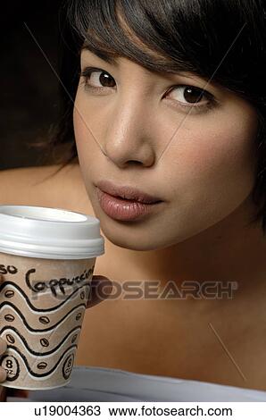 Stock Image - Woman with a cappuccino to go. Fotosearch