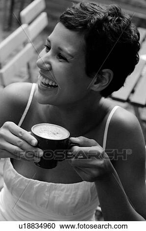 Stock Image - Young woman enjoying a cappuccino. Fotosearch