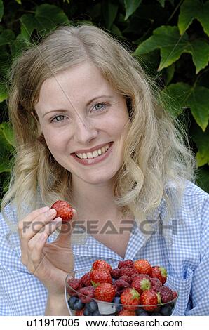 Young woman holding a bowl with fruits View Large Photo Image Stock Photography - Young woman holding a bowl with fruits. Fotosearch