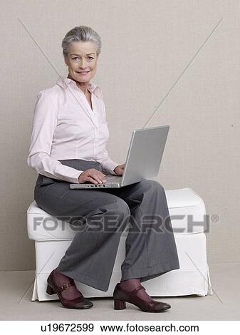 Stock Photo - Senior citizen in business wear using a laptop. Fotosearch