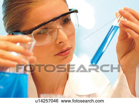 Female scientist looking at test tube View Large Photo Image Stock Photograph - Female scientist looking at test tube. Fotosearch