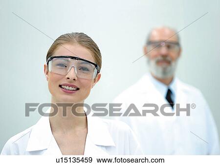 Stock Photo - looking at camera, lab coat, white background, indoor, scientists, lifestyle. Fotosearch