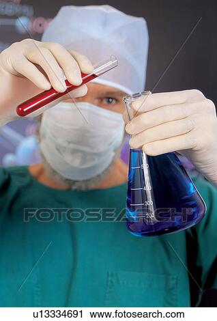 Stock Image - Male scientist mixing liquids. Fotosearch