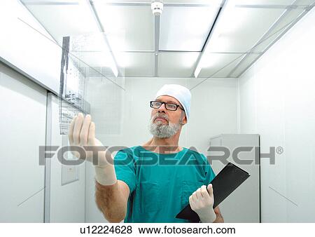 Stock Photo - Man looking at a lab sheet. Fotosearch