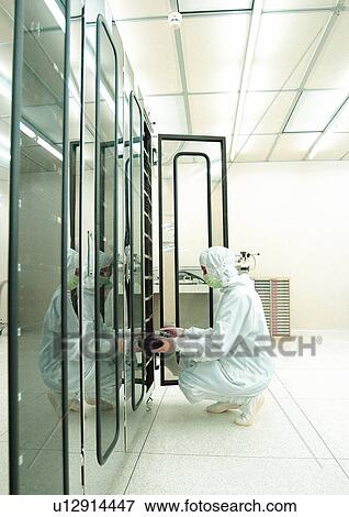 Stock Photo - Technician in protective clothes examining object. Fotosearch