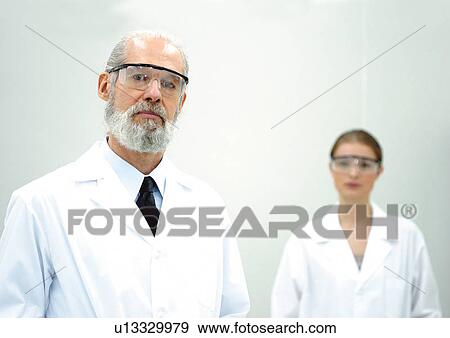 Stock Photo - Two scientist with protective glasses in white lab coats. Fotosearch