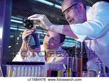 Two scientists mixing liquids View Large Photo Image Stock Photograph - Two scientists mixing liquids . Fotosearch