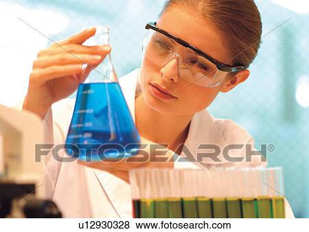 Stock Photo - Woman looking at a beaker . Fotosearch