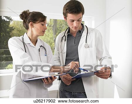 Doctors discussing a file View Large Photo Image Stock Image - Doctors discussing a file. Fotosearch