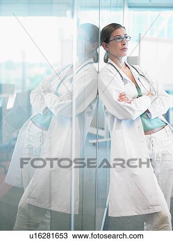 Female doctor leaning on glass wall in lobby. View Large Photo Image Stock Image - Female doctor leaning on glass wall in lobby.. Fotosearch