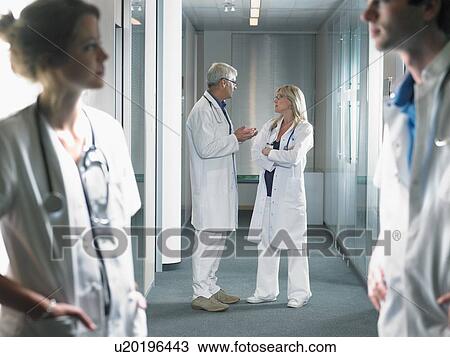 Group of doctors in discussion in hospital lobby. View Large Photo Image Stock Image - Group of doctors in discussion in hospital lobby.. Fotosearch