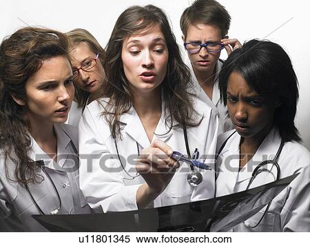 Group of doctors looking at an x-ray View Large Photo Image Stock Photography - Group of doctors looking at an x-ray. Fotosearch