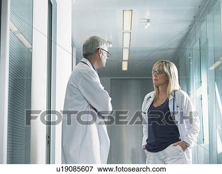 Male doctor and female doctor in discussion in hospital lobby. View Large Photo Image Stock Photo - Male doctor and female doctor in discussion in hospital lobby.. Fotosearch