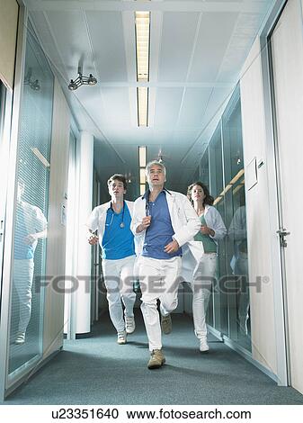 Three doctors running in a lobby of a hospital. View Large Photo Image Stock Image - Three doctors running in a lobby of a hospital.. Fotosearch