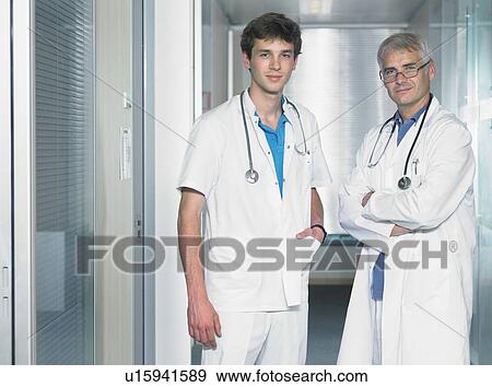 Stock Photo - Two male doctors in hospital lobby.. Fotosearch