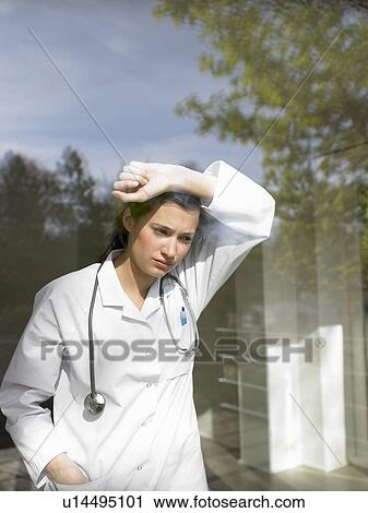 Stock Image - Young female doctor by the window. Fotosearch