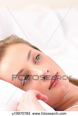 Stock Image - indoors alone, lying down, longhair, indoors, young woman, beautiful. Fotosearch