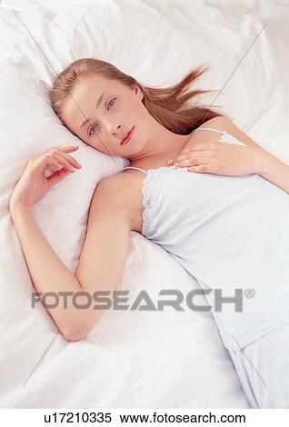 Stock Photography - indoors, hand on chest, young, beauty, portrait, relaxing, lying down. Fotosearch
