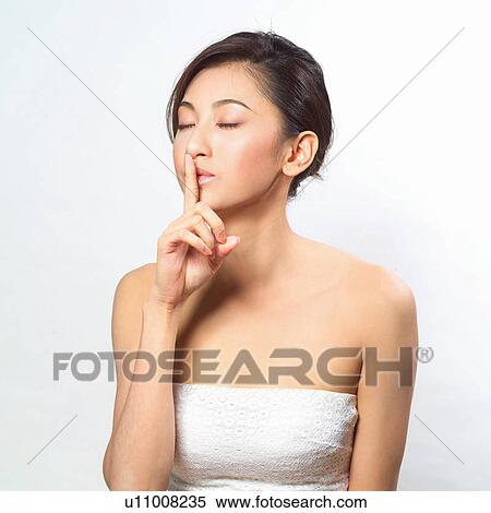 Asian woman with her finger to her mouth View Large Photo Image Stock Photography - Asian woman with her finger to her mouth . Fotosearch