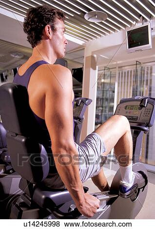 Stock Photo - endurance, one person, fitness gym, body, exercise bike, man only, culture. Fotosearch