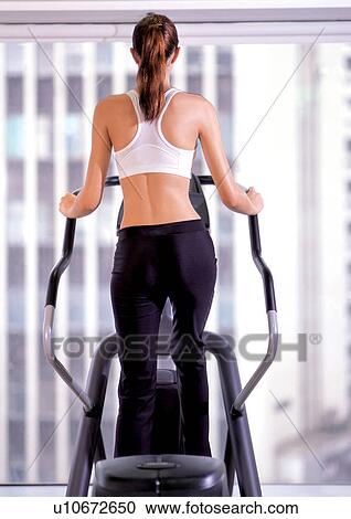 Woman working out on an elliptical View Large Photo Image Stock Image - Woman working out on an elliptical . Fotosearch