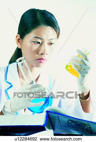 Stock Image - Close-Up, Beaker, Chemical, Book, Black Hair, Asian Ethnicity. Fotosearch