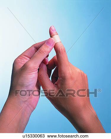 Stock Image - Bandage, Human Finger, Colored Background, Close-Up, Applying. Fotosearch