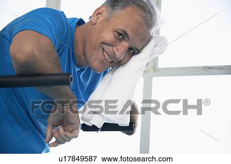 Stock Photo - Man drying sweat from his face. Fotosearch
