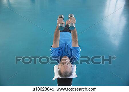 Man weight training on bench (high angle view) View Large Photo Image Stock Photography - Man weight training on bench (high angle view). Fotosearch