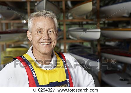 Mature man by kayaks View Large Photo Image Stock Photo - Mature man by kayaks. Fotosearch