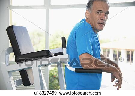 Mature man on exercise machine (portrait) View Large Photo Image Stock Photo - Mature man on exercise machine (portrait). Fotosearch