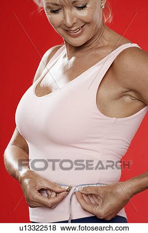 Mature woman measuring waist View Large Photo Image Stock Photo - Mature woman measuring waist. Fotosearch