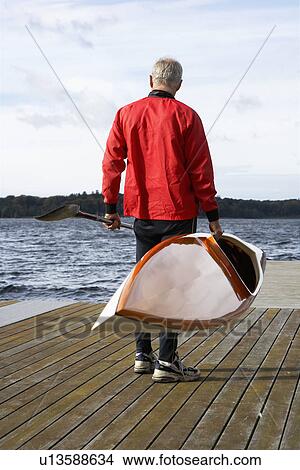 Senior man holding a kayak View Large Photo Image Picture - Senior man holding a kayak. Fotosearch