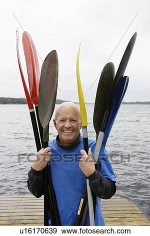 Senior man holding oars View Large Photo Image Stock Photo - Senior man holding oars. Fotosearch