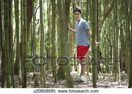 Young man stretching hamstrings in forest View Large Photo Image Stock Photography - Young man stretching hamstrings in forest. Fotosearch