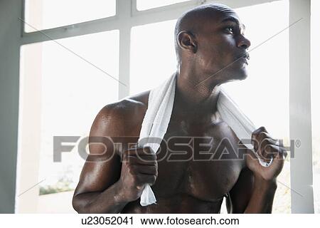 Stock Image - Young man with towel around neck. Fotosearch