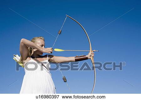 Stock Photo - Young woman arrow shooting. Fotosearch