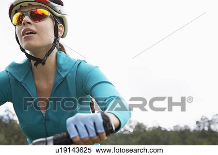 Stock Photography - Young woman cycling, close-up. Fotosearch