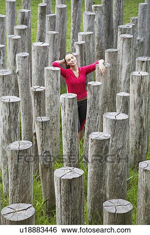 Stock Photograph - Young woman surrounded by stumps, high angle view. Fotosearch